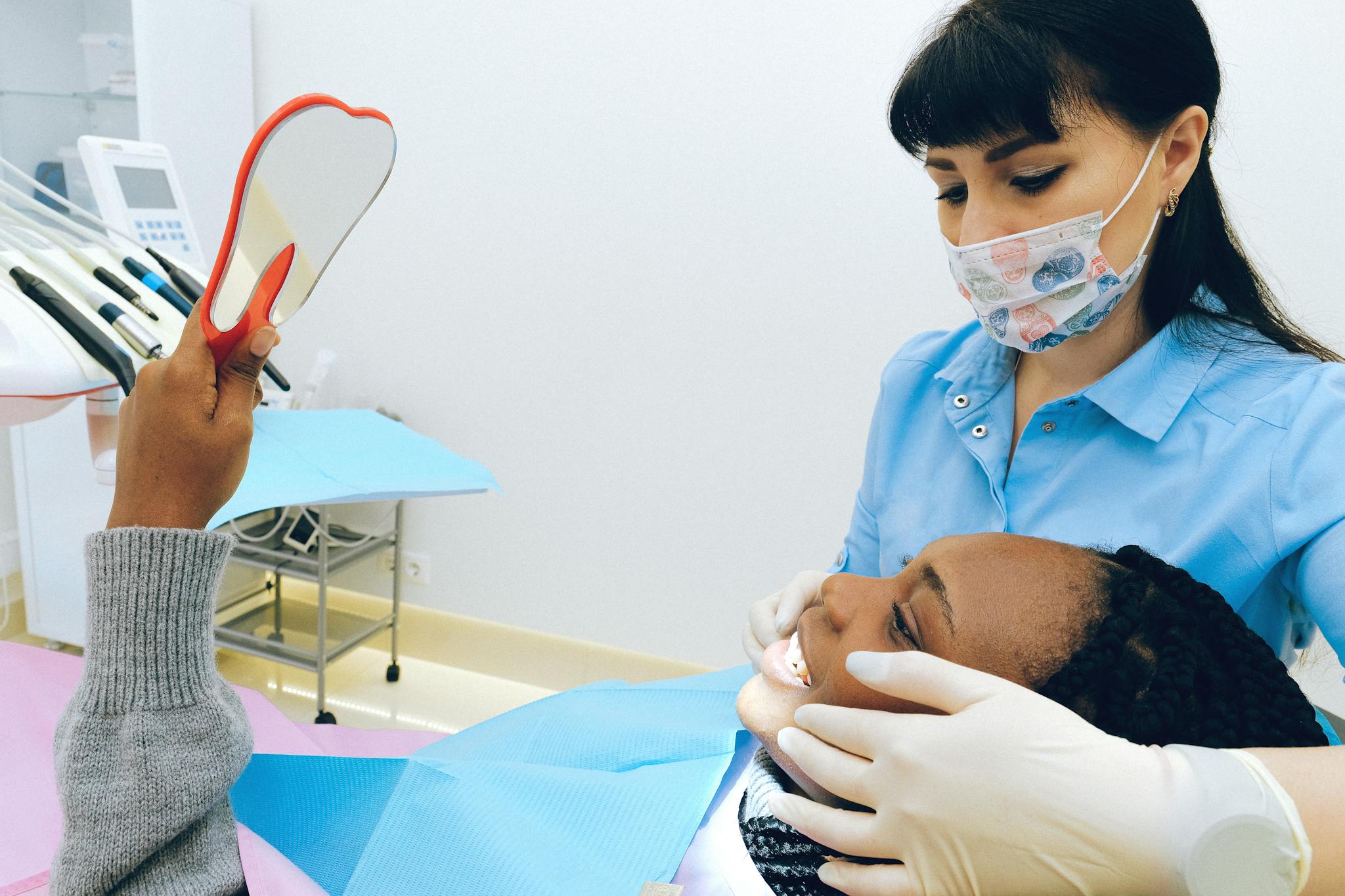 staff with patient looking at smile in mirror